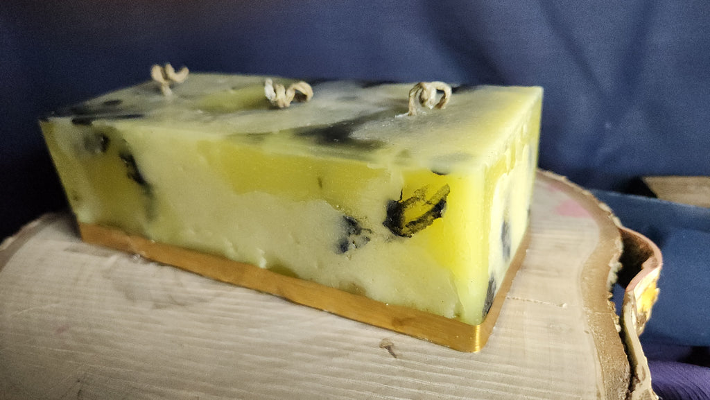 A brick shaped or rectangle block beeswax candle. Marbled with natural beeswax and has three wicks made of braided hemp. Glows in the dark when lights are off this one white glows blue.